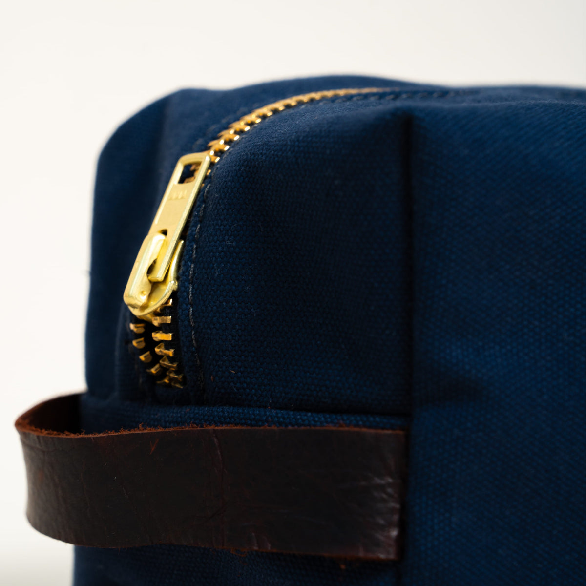 Blue pouch with a gold zipper on a white background