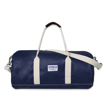 Navy duffel bag with white handles and a visible brand label on a white background