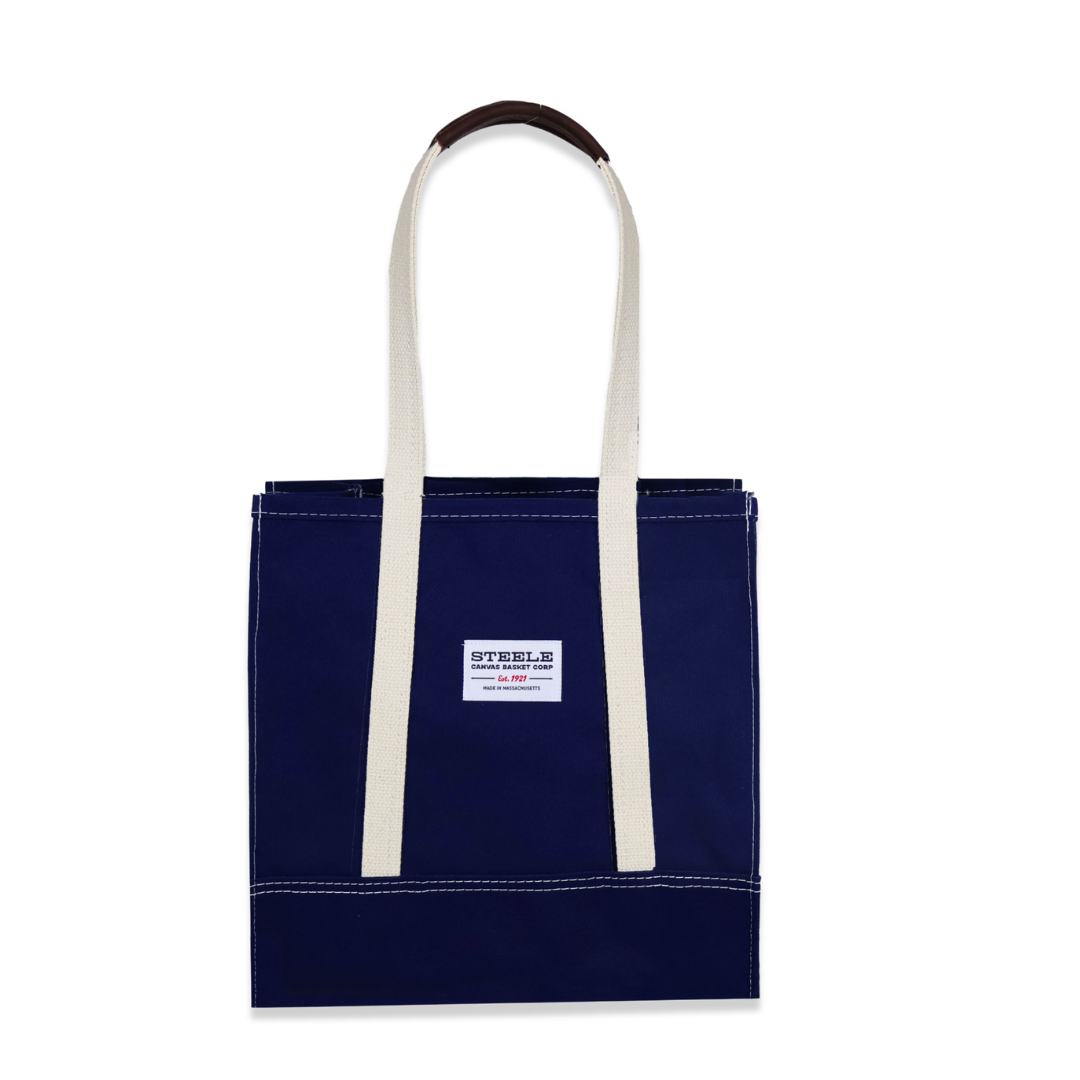 Navy tote bag with white handles on a white background