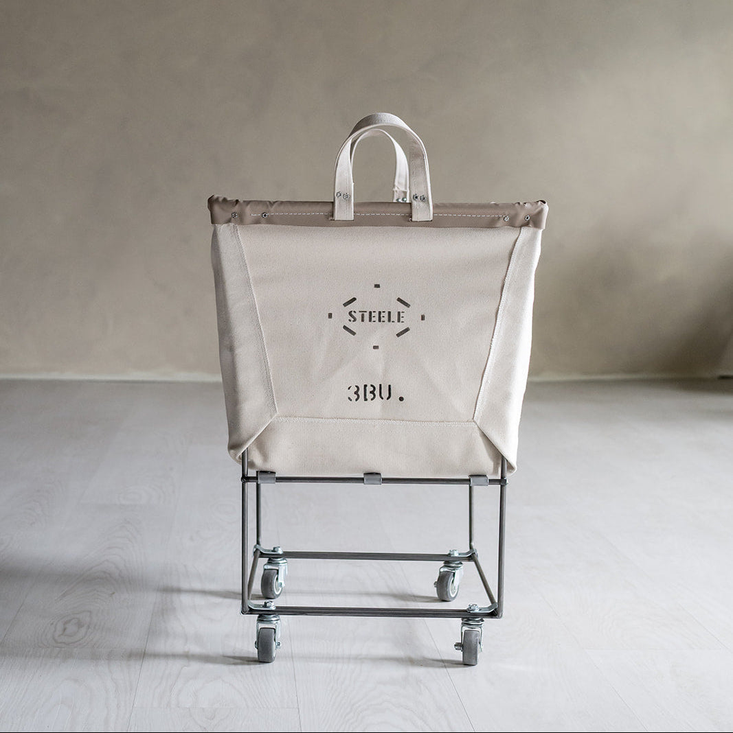 natural canvas laundry cart with a white bag on a gray background