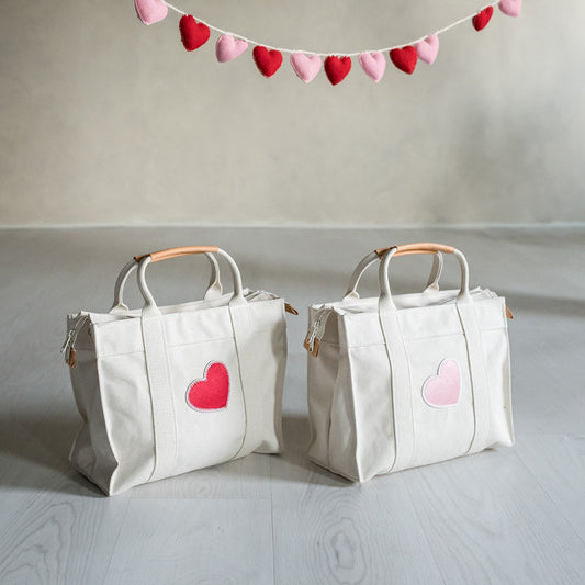 two natural canvas tote bags with valentine's day patches on them