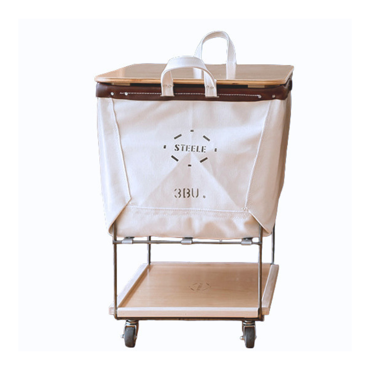 A wheeled laundry truck with natural canvas laundry basket, a light wood top and bottom shelf, and dark brown leather trim, shown on a plain white background.