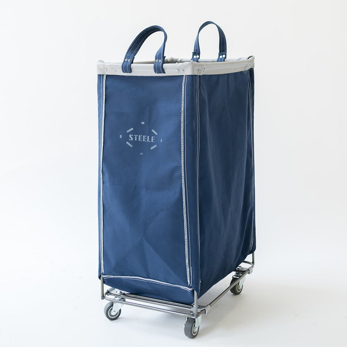 A navy blue fabric laundry hamper with silver trim and handles, mounted on a chrome rolling cart with casters. The brand name 'STEFIE' is printed in white on the front.