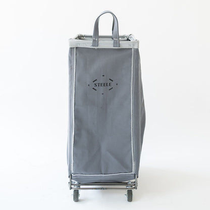 A gray fabric shopping cart with a top handle and wheels, featuring the brand name 'STELLK' printed on the front, set against a plain white background.