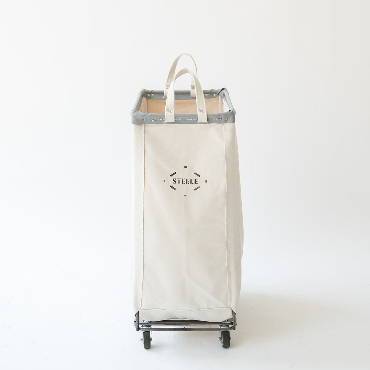 An off-white canvas laundry hamper with gray trim and black wheels, featuring a top handle and a black printed logo on the front, set against a plain white background.