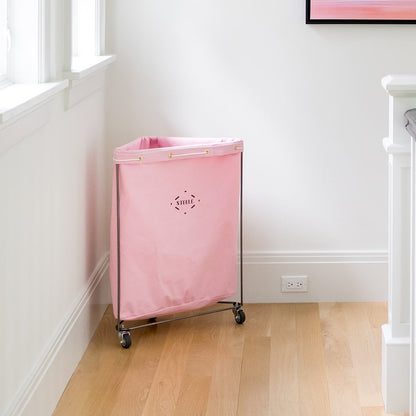 corner laundry basket in a blush pink color