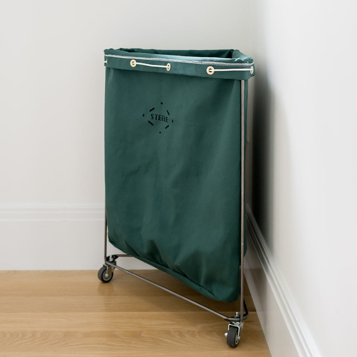 corner laundry hamper in hunter green from a side angle