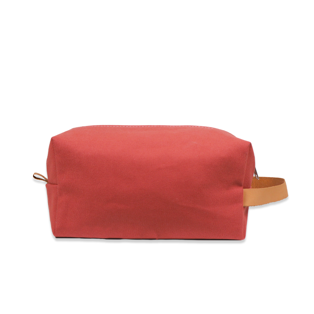 Red toiletry bag with a strap on a white background