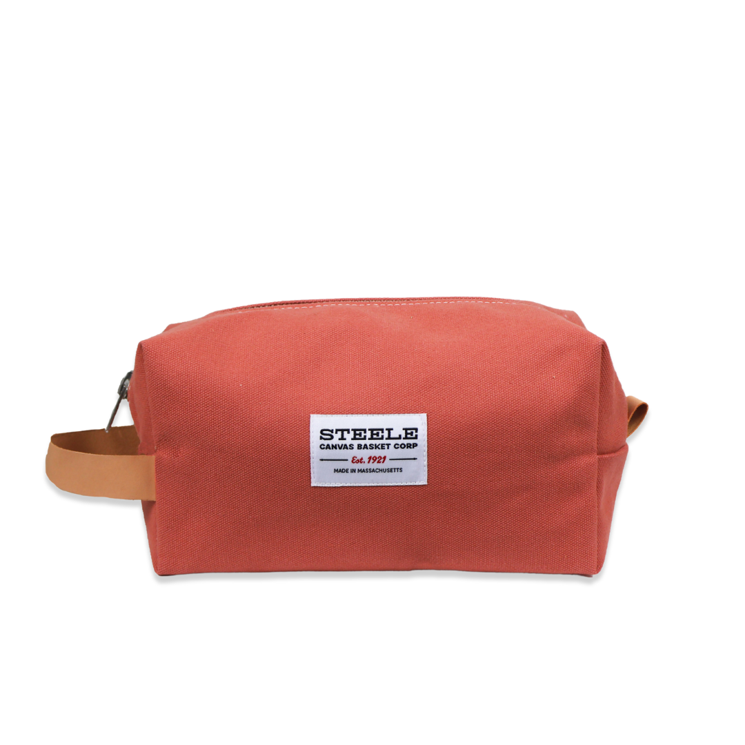 Red toiletry bag with a visible brand label on a white background