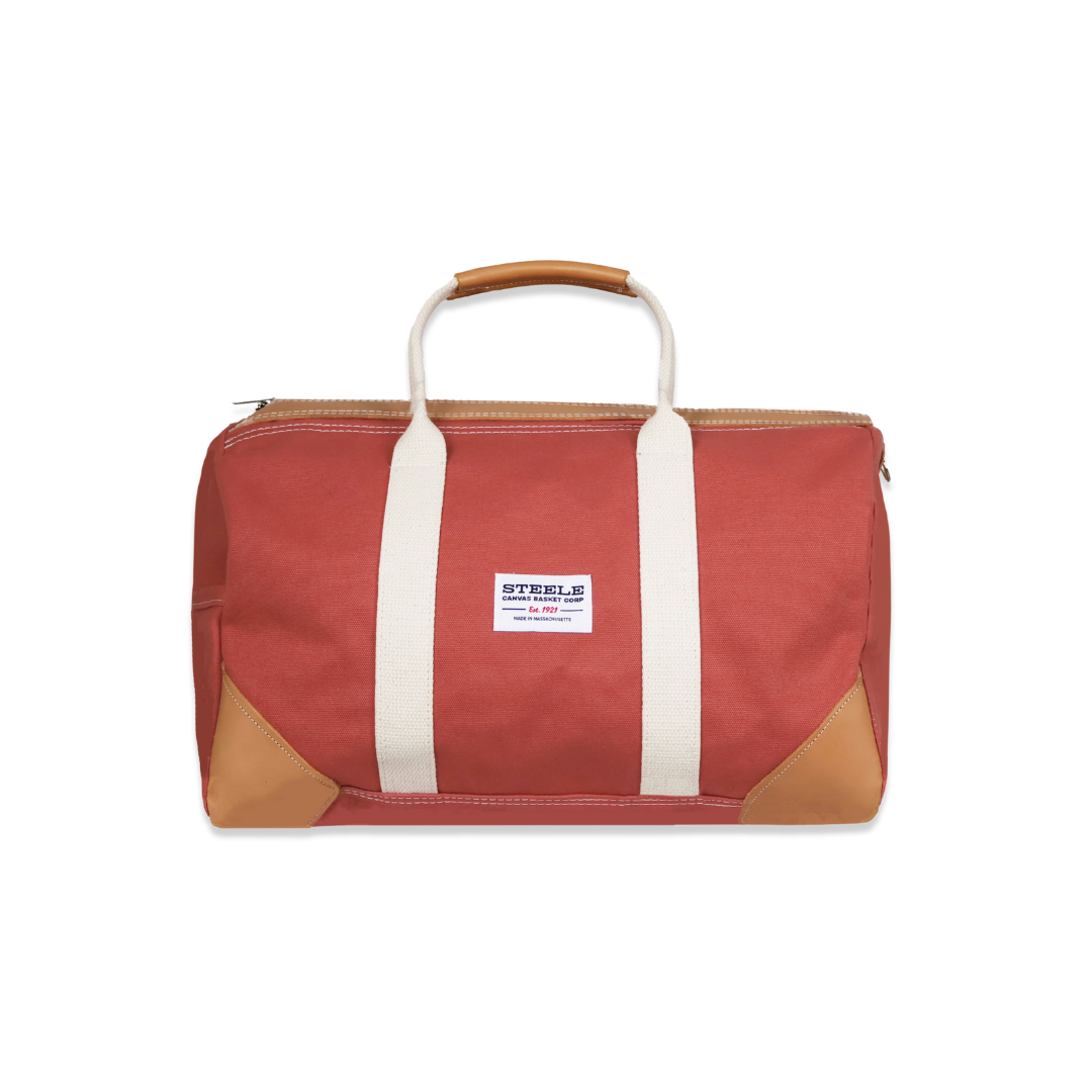 Red duffel bag with brown accents and a visible brand label on a white background