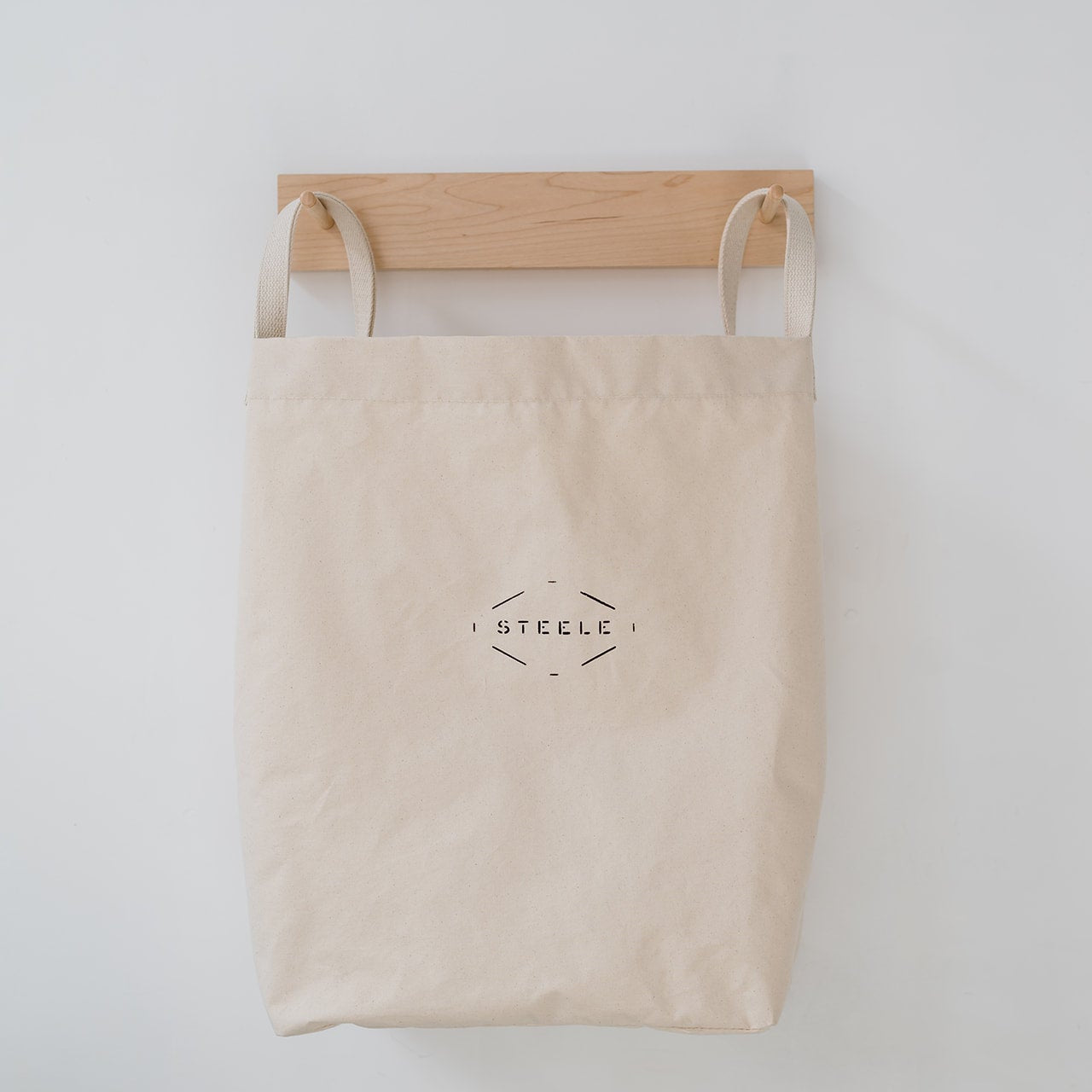 wall hanging canvas laundry bag on wooden hooks