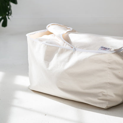 White fabric bag with a visible brand label on a light surface.