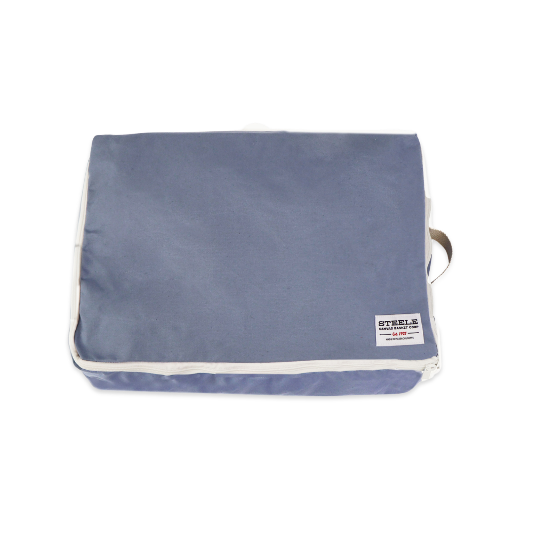 A rectangular blue-gray fabric pouch or organizer bag with white piping and a small white brand label on the lower right, shown on a plain white background.