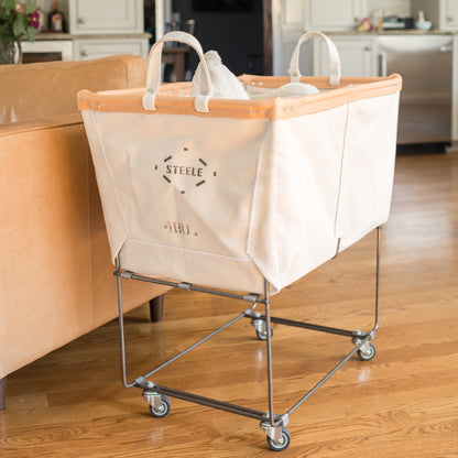 Laundry cart with leather trim labeled 'Steele' in a kitchen setting
