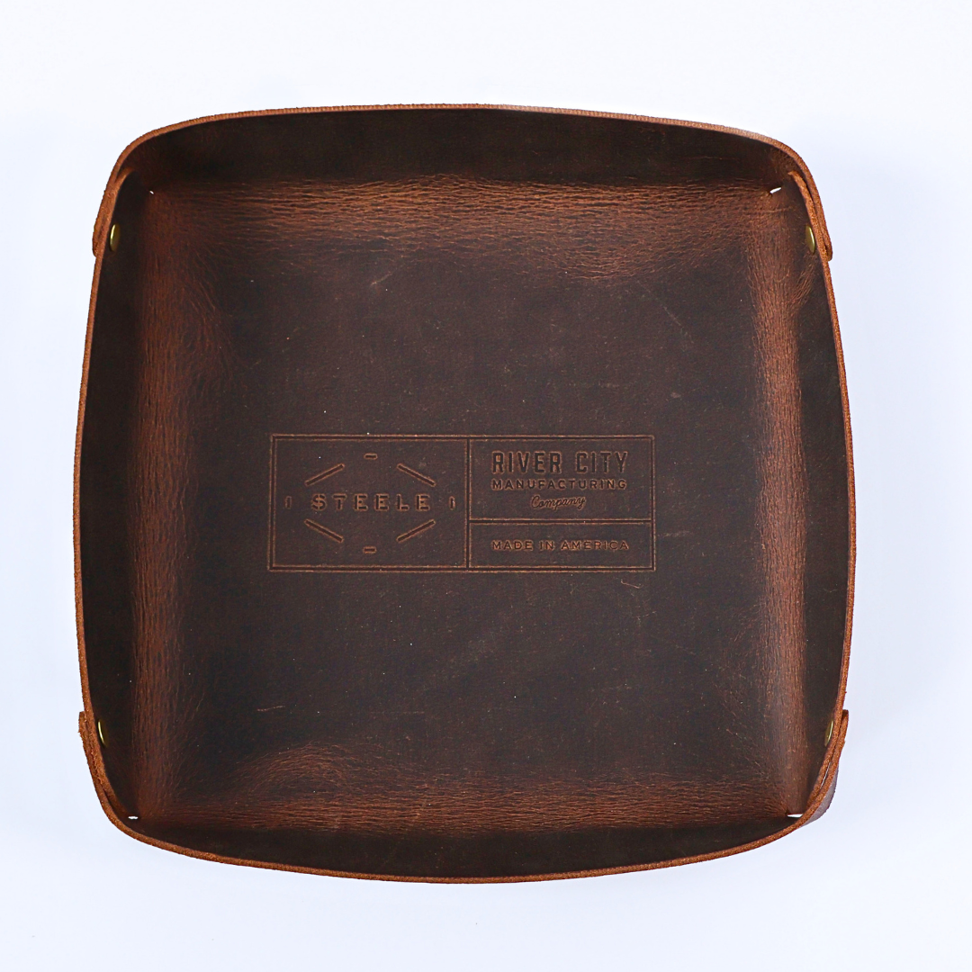 Brown leather tray with 'River City Leather Goods' branding on a white background