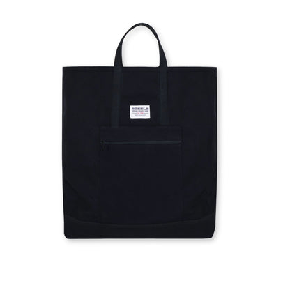 Black tote bag with a small white label on a white background
