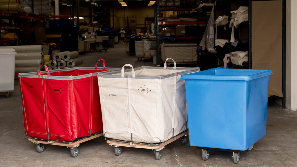 Three laundry carts in red, white, and blue in a warehouse setting.