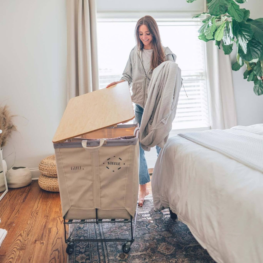 women putting a blanket into a canvas laundry truck